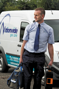 A Nationwide Gas Care engineer in uniform beside a company van